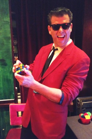 Emcee dressed in 80s style clothes with Rubik's Cube